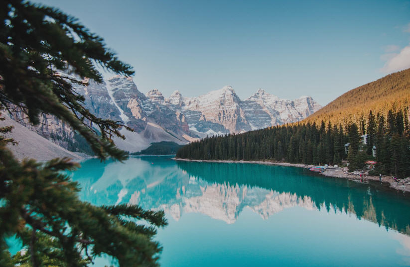 Majestic Canadian Rockies in Banff National Park, featuring snow-capped peaks, turquoise lakes, and dense pine forests.