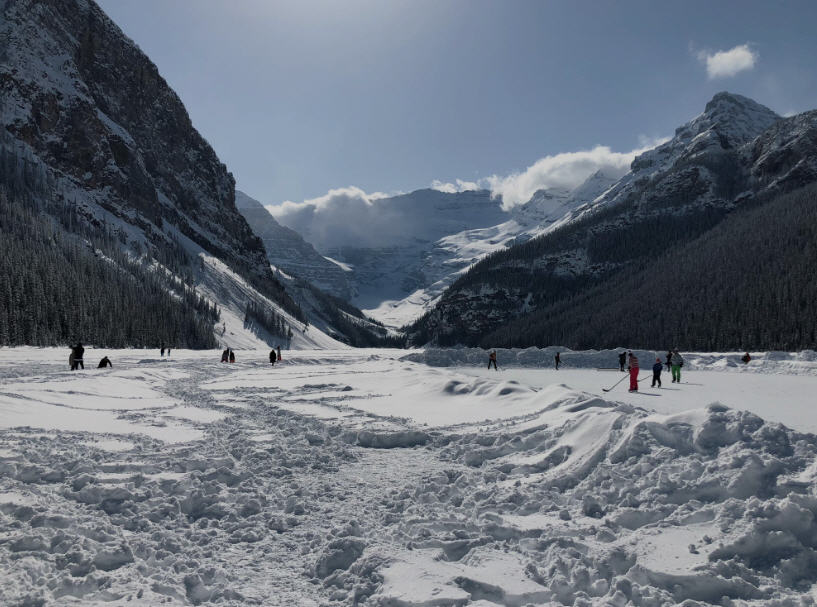 Emerald waters of Lake Louise in Banff National Park, surrounded by towering mountains and the Fairmont Chateau Lake Louise.