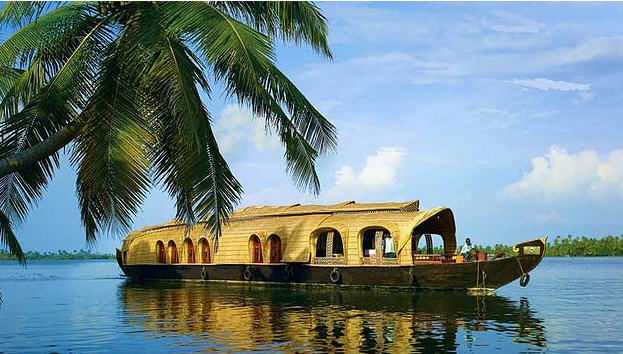 Golden sunset over the Kerala Backwaters, reflecting on the still water and silhouetting a kettuvallam (houseboat).