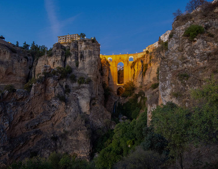 Panoramic view of Ronda, Spain, a historic town perched dramatically on a clifftop overlooking a deep gorge.