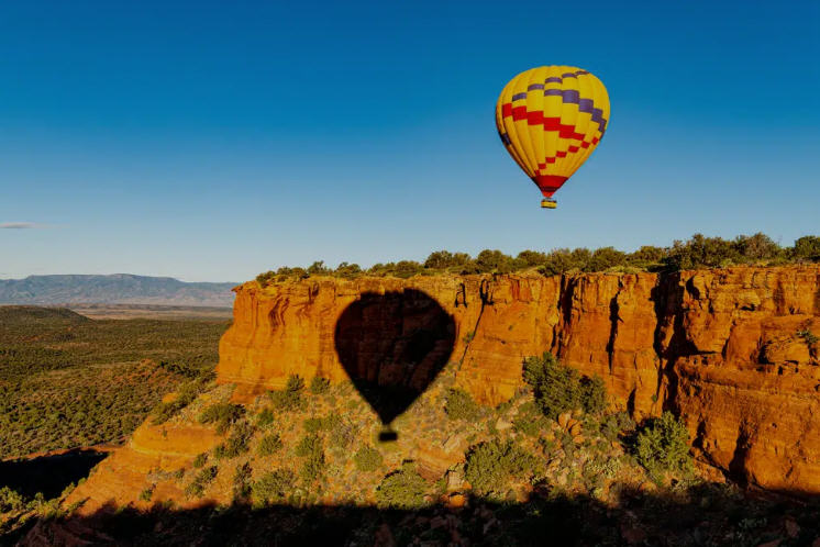 Sunset over Sedona, casting long shadows and shades of orange and red across the desert landscape.