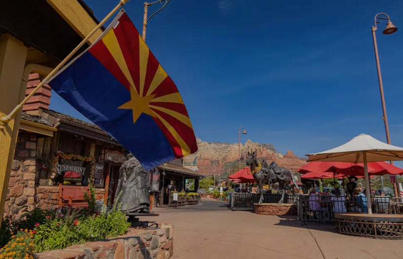 Panoramic view of Sedona, showing the town nestled amidst towering red rock buttes and distant mountains.