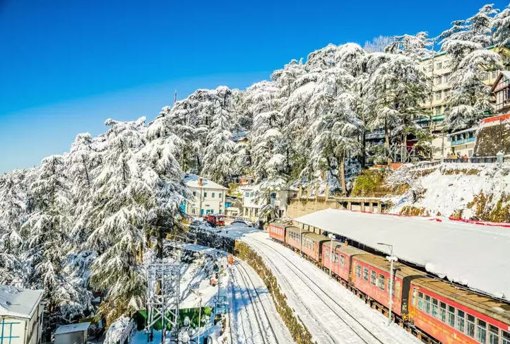The Ridge in Shimla, bustling with people, framed by the Christ Church and distant snow-capped mountains.