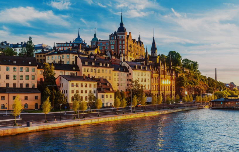 Panoramic view of Stockholm archipelago, showcasing islands dotted with houses, lush greenery, and sailboats in the Baltic Sea.