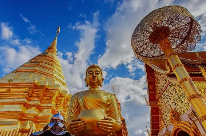Intricate carvings and weathered Buddha statues in the courtyard of Wat Chedi Luang, Chiang Mai.
