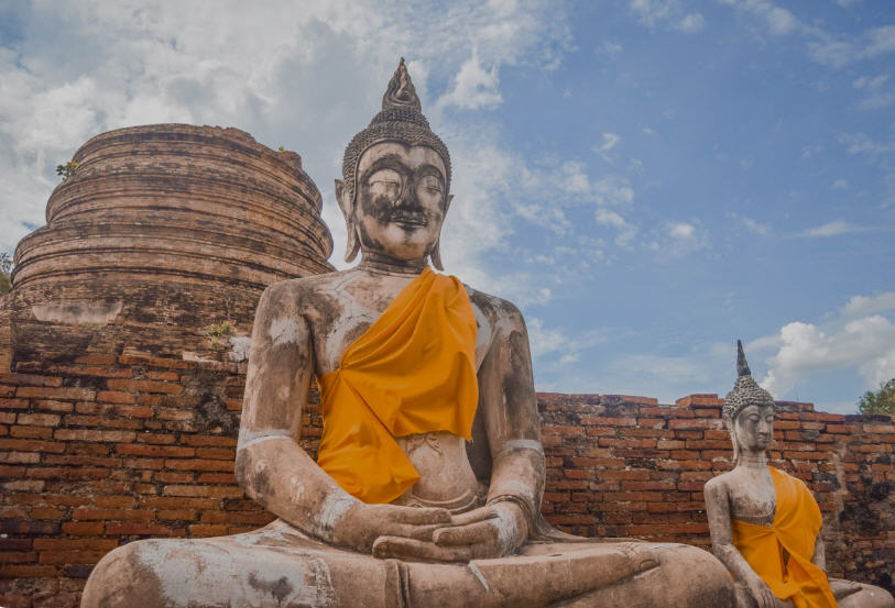 Iconic Buddha head entwined in tree roots at Wat Mahathat, Ayutthaya, Thailand.