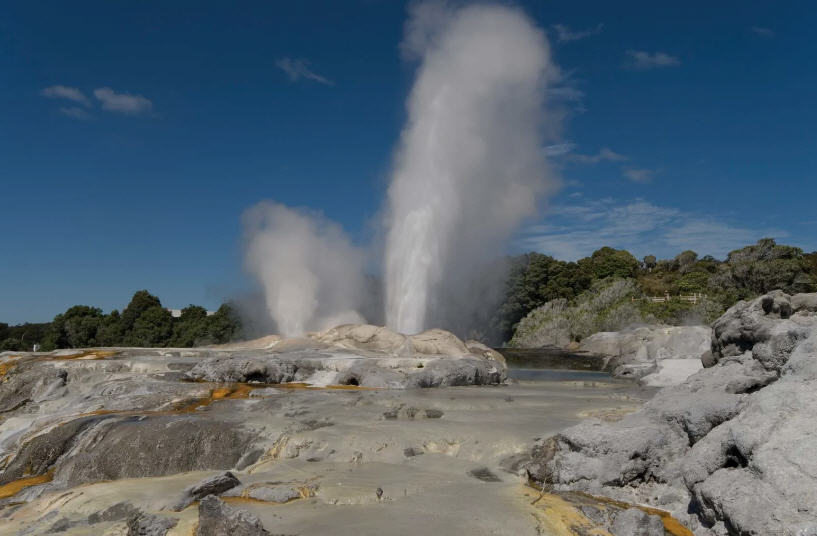 Panoramic view of Rotorua, New Zealand, showcasing Lake Rotorua, the city center, and surrounding hills.